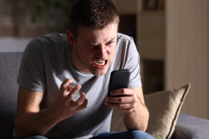angry man looking at phone after call from direct home buyers