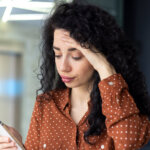 5 Ways To Get Out of Your Mortgage in San Antonio-concerned woman looking at phone in workplace