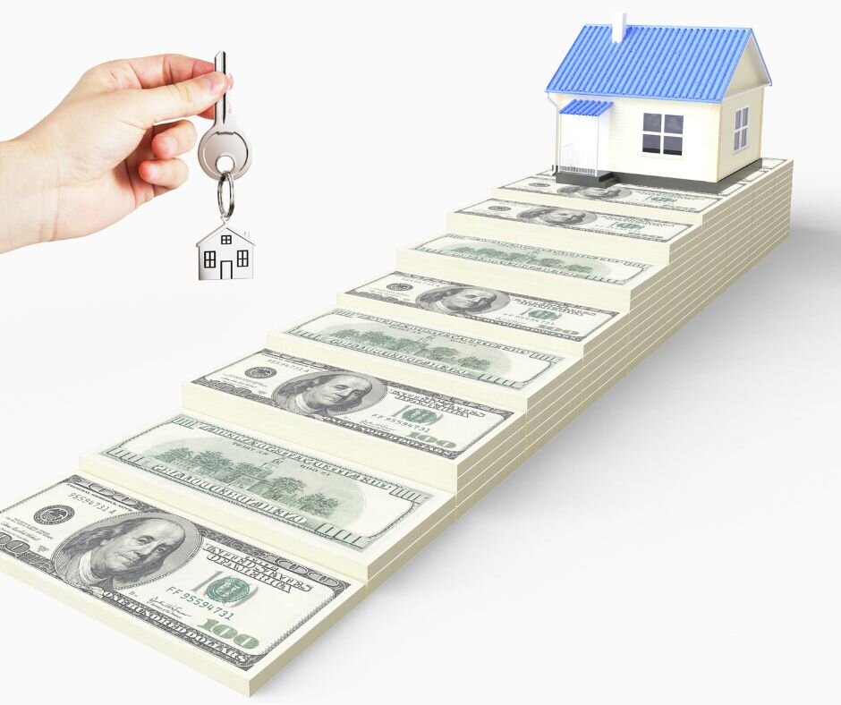 A hand holds house keys above stacked $100 bills forming steps to a blue-roofed model house, symbolizing the financial steps you take when you sell your house to a direct buyer.