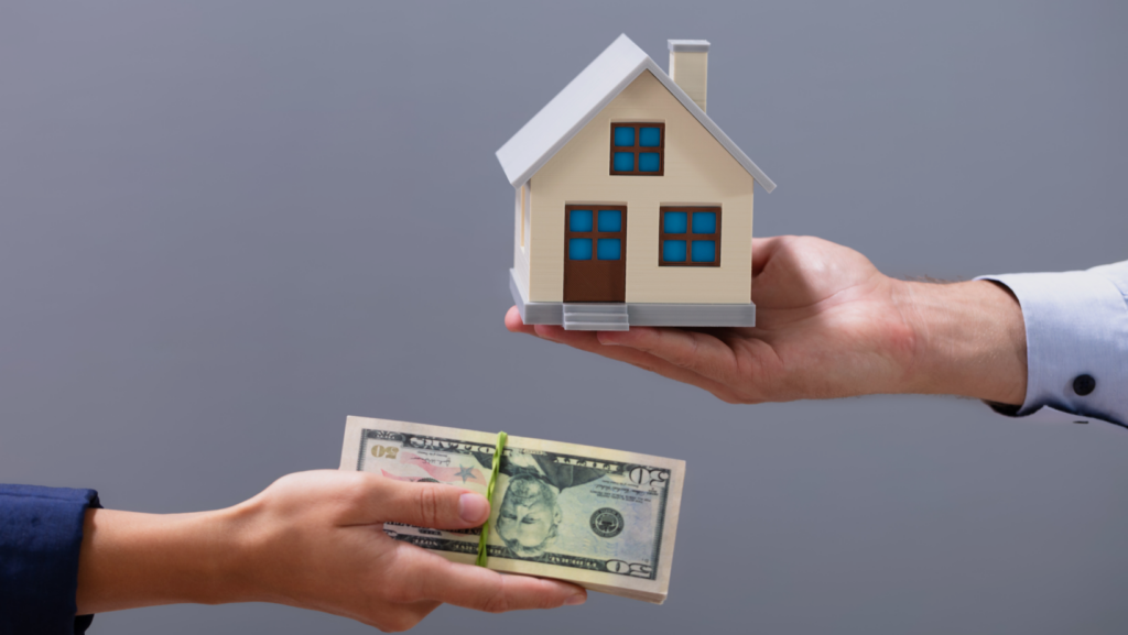 A person hands over a stack of cash while another holds a model house, capturing the essence of Sell My House Fast in Fort Worth: A Quick Guide and highlighting the speed and simplicity of real estate transactions.