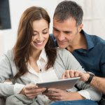 a couple researching their home's value to sell it without a realtor