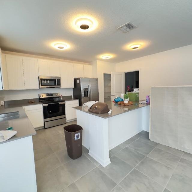 Kitchen at 1002 John Jacob Rd with white cabinets, a center island and stainless-steel appliances