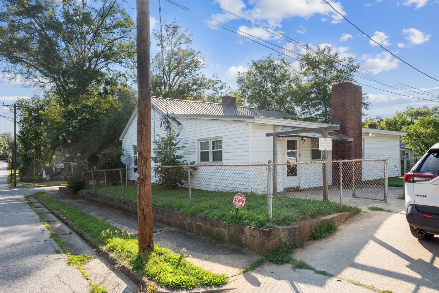 House exterior with light siding, brick chimney and front steps