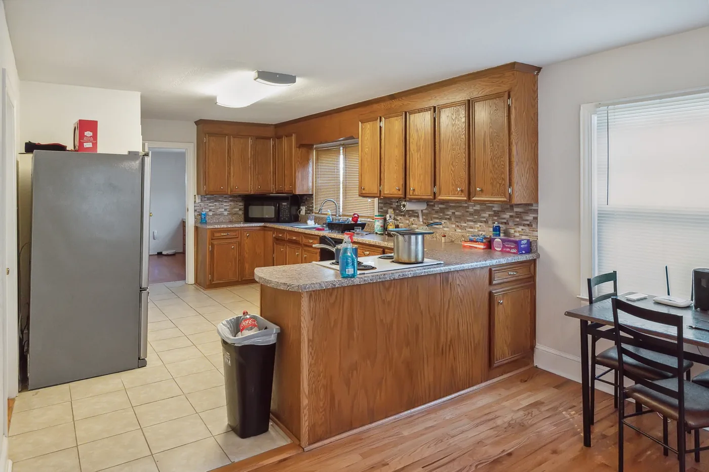 Kitchen with wood cabinets, refrigerator and dining table