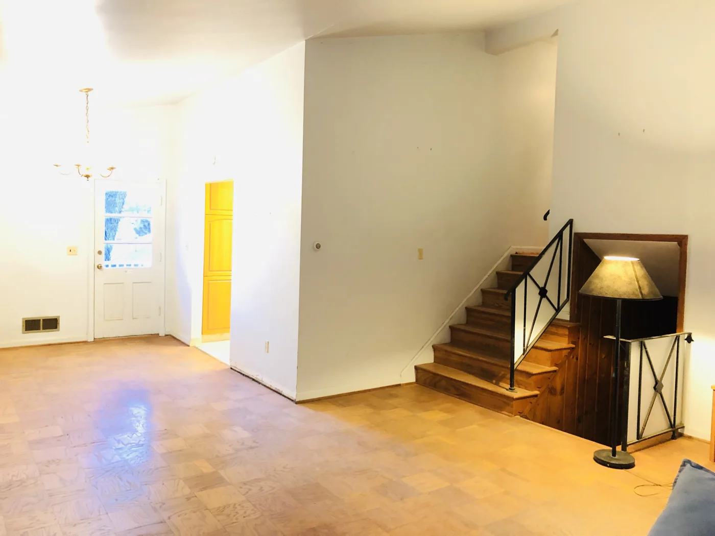Empty living area with wood flooring and stairs