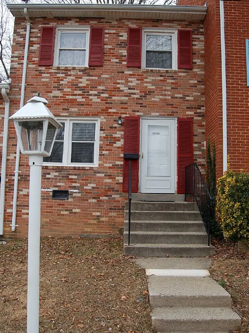 Brick townhouse with red shutters and front steps at 14388 Fontaine Ct, Woodbridge, Virginia