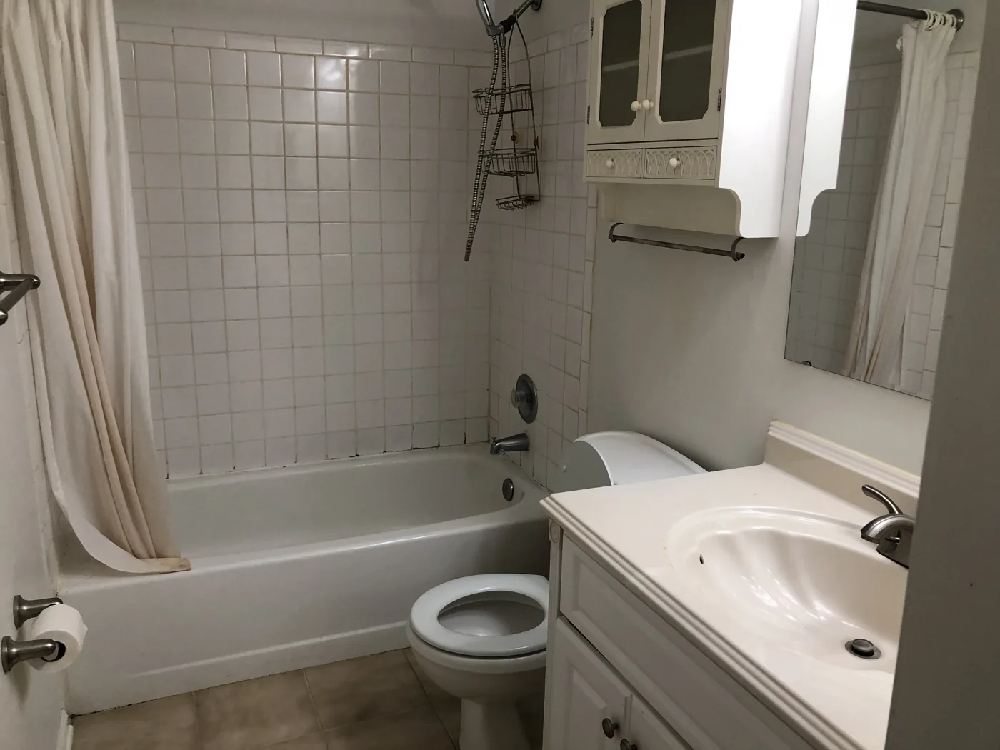 Bathroom with a tiled tub surround, toilet and vanity