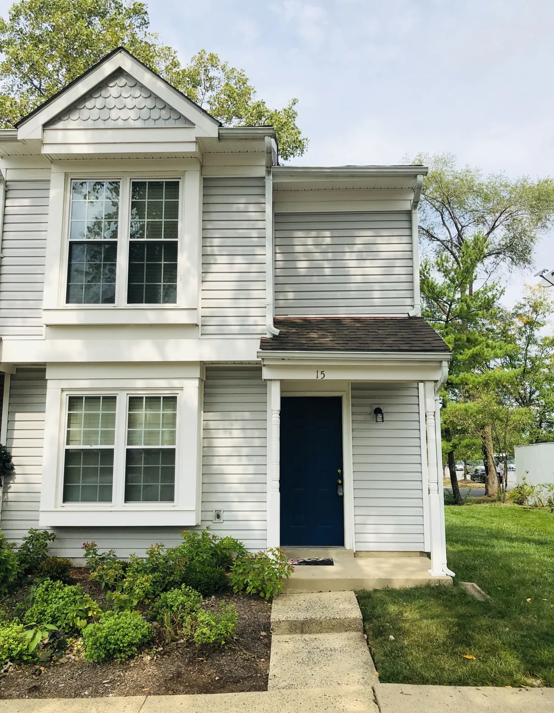 Two-story home with light siding and a front walkway