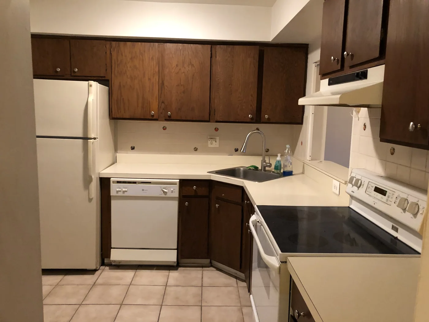 Kitchen with dark wood cabinets and white appliances