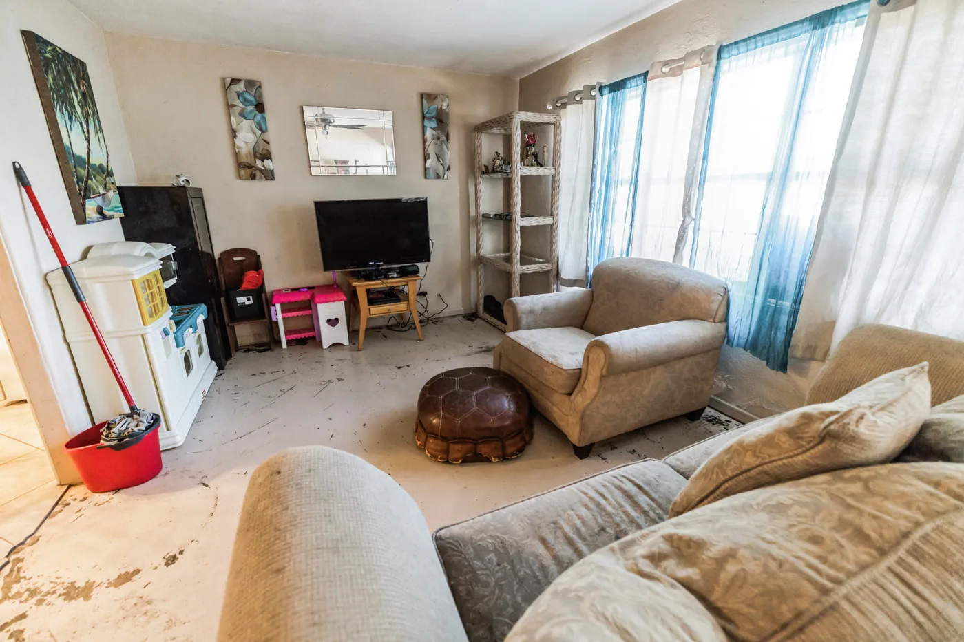 Living room with upholstered seating, curtains and belongings