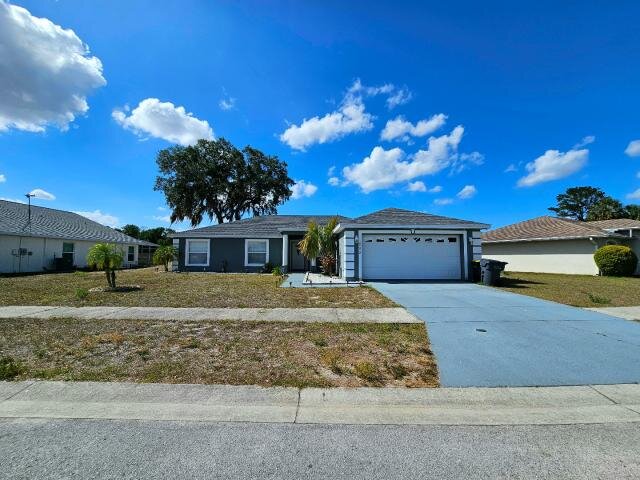 Front exterior of 205 Golf Aire Blvd in Haines City, with a two-car garage, driveway and lawn