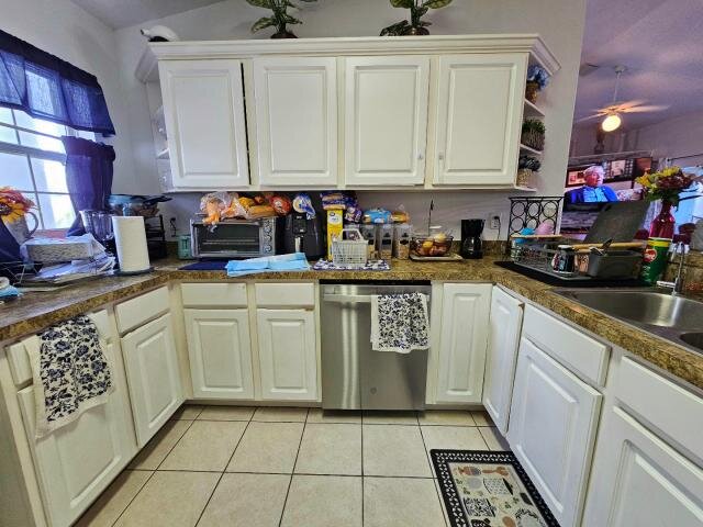 Kitchen at 205 Golf Aire Blvd with white cabinets, tiled floor and stainless-steel dishwasher