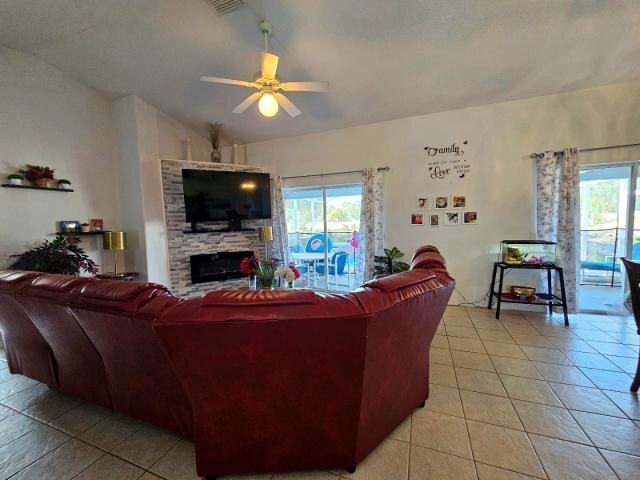 Living room at 205 Golf Aire Blvd with tile flooring, a red sectional sofa and sliding glass doors