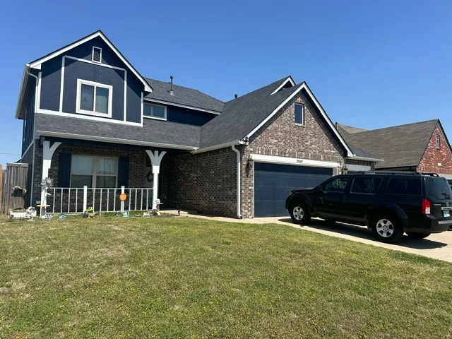 Front of 20507 East 31st Place South with attached garage and lawn