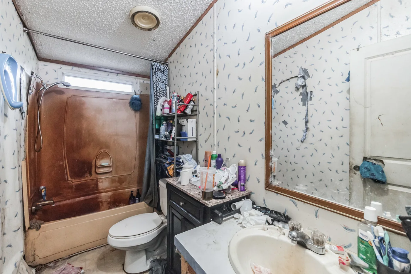 Bathroom with a tub enclosure, sink and visible wall wear