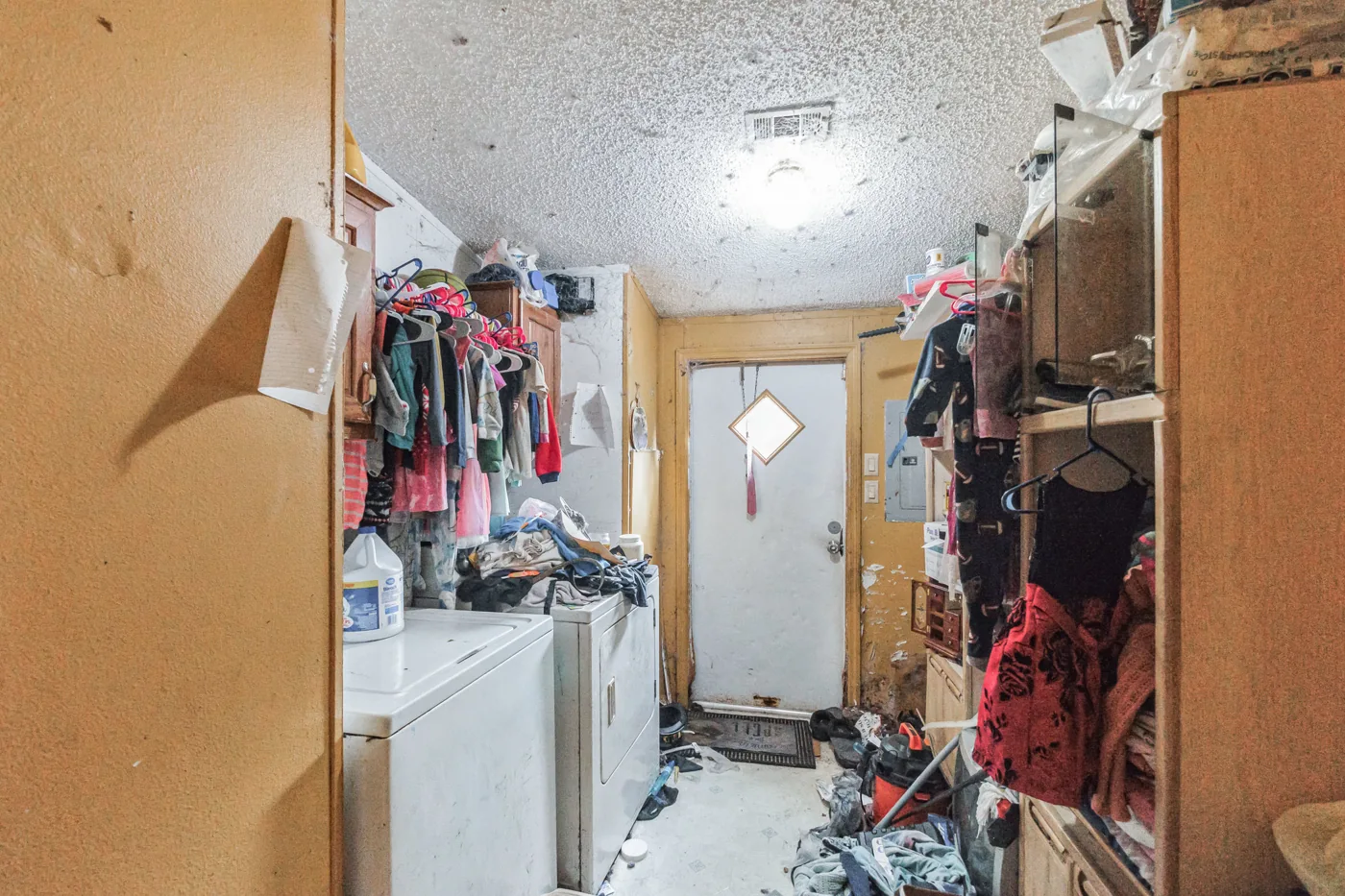 Utility area with appliances, clothing and assorted belongings
