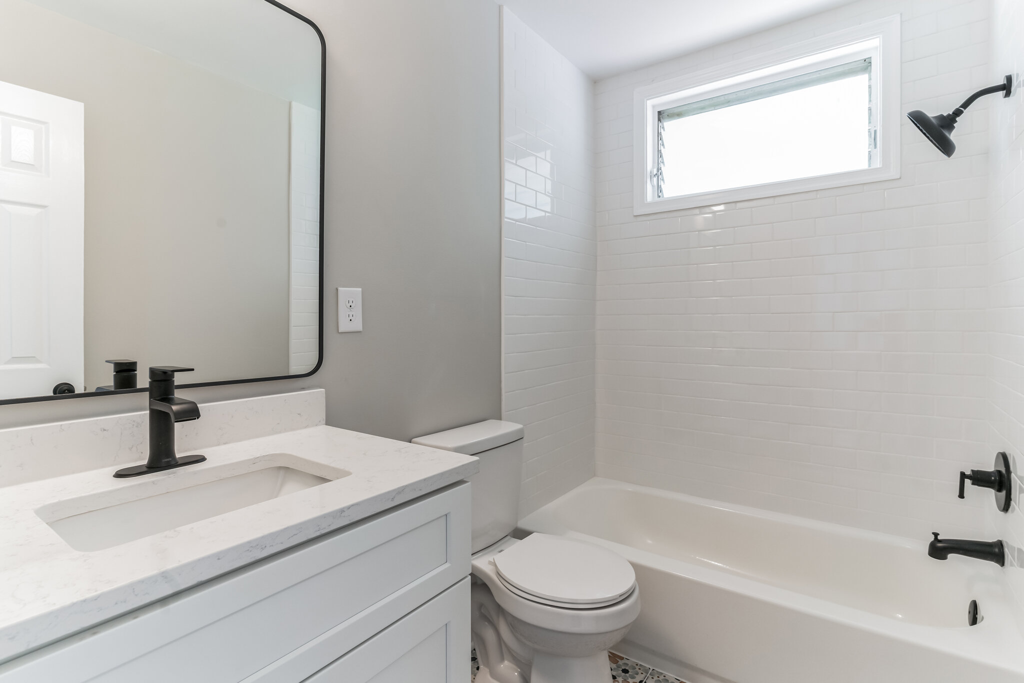 Bathroom at 22519 Joan Dr after renovation, showing the vanity and tiled tub surround