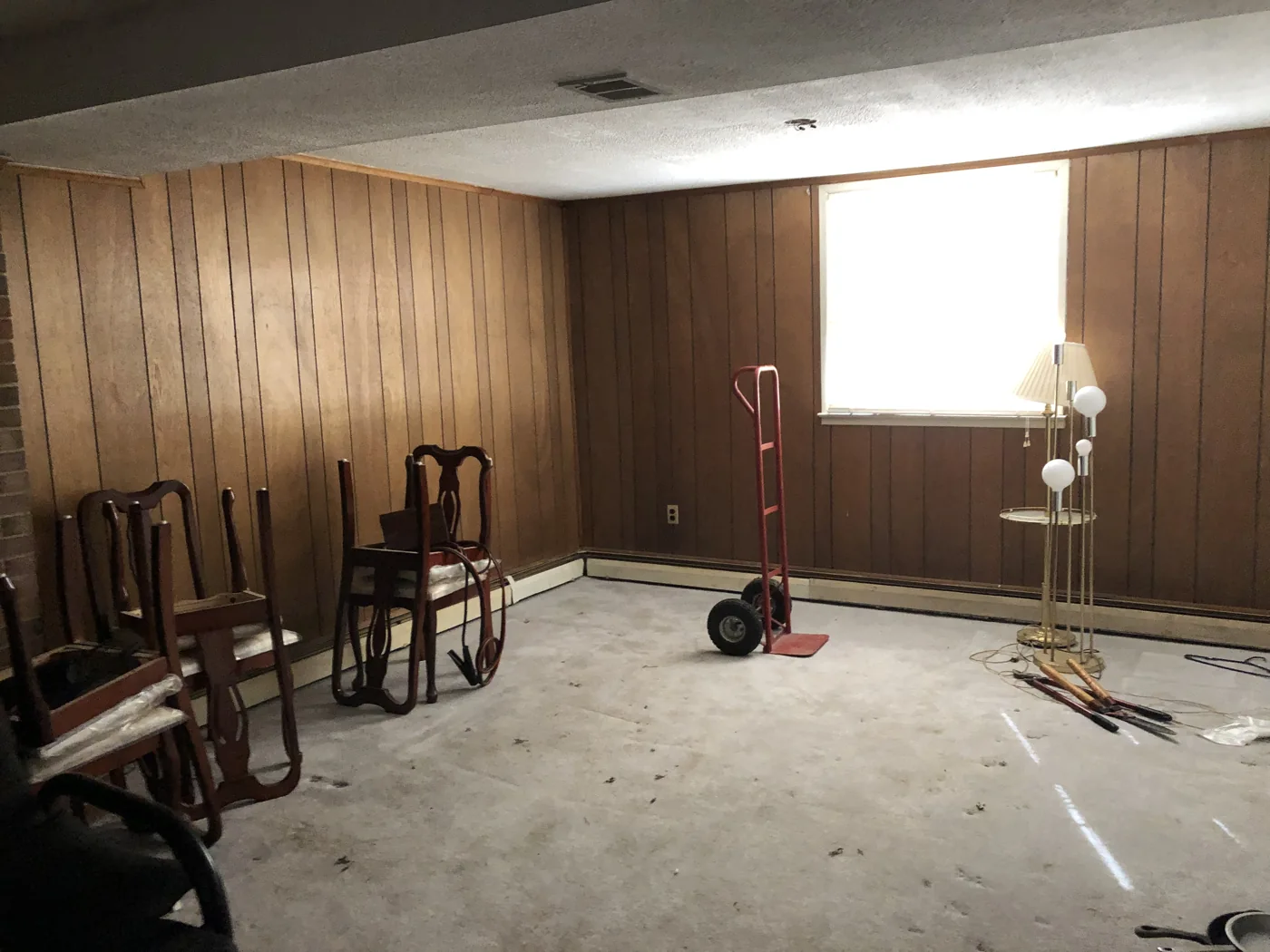 Wood-paneled room with carpet and remaining furniture