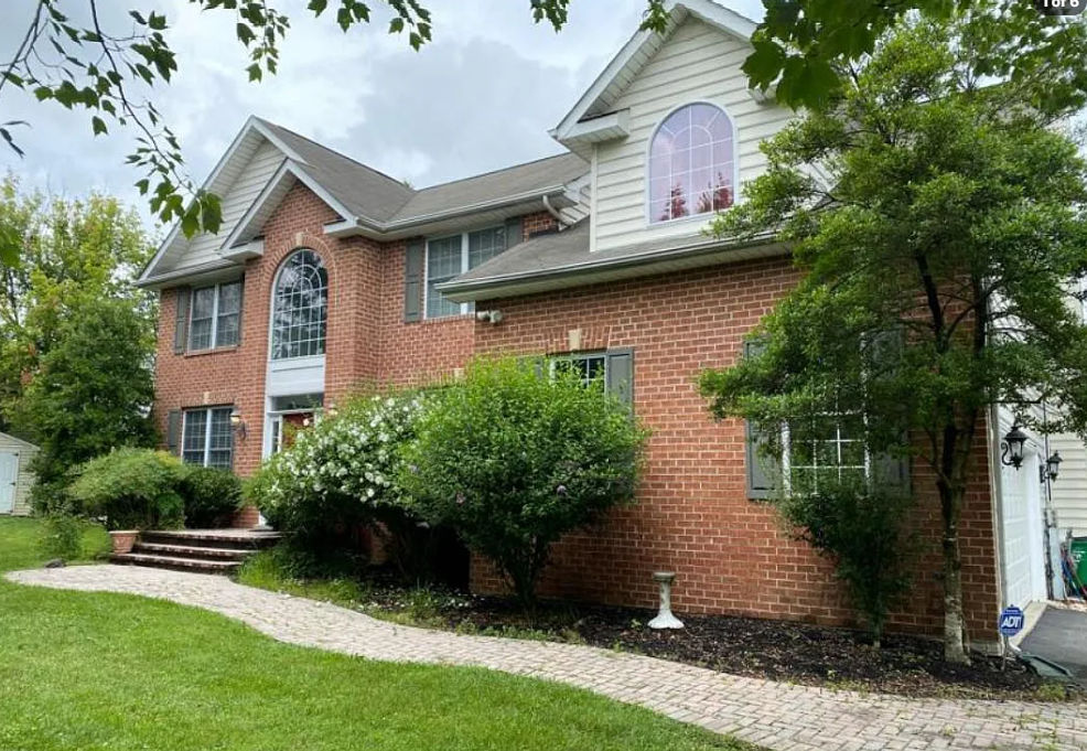 Brick-front exterior of 5823 Montgomery Rd in Elkridge, with lawn and shrubs