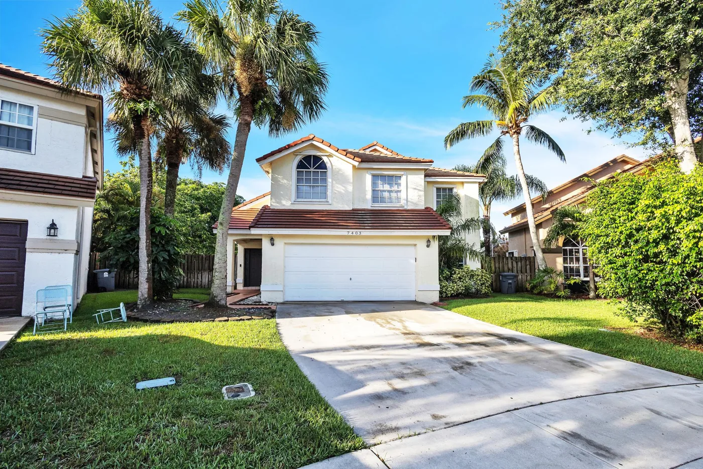 Front exterior and driveway after renovation at 7403 Ashley Shores Circle in Lake Worth, Florida