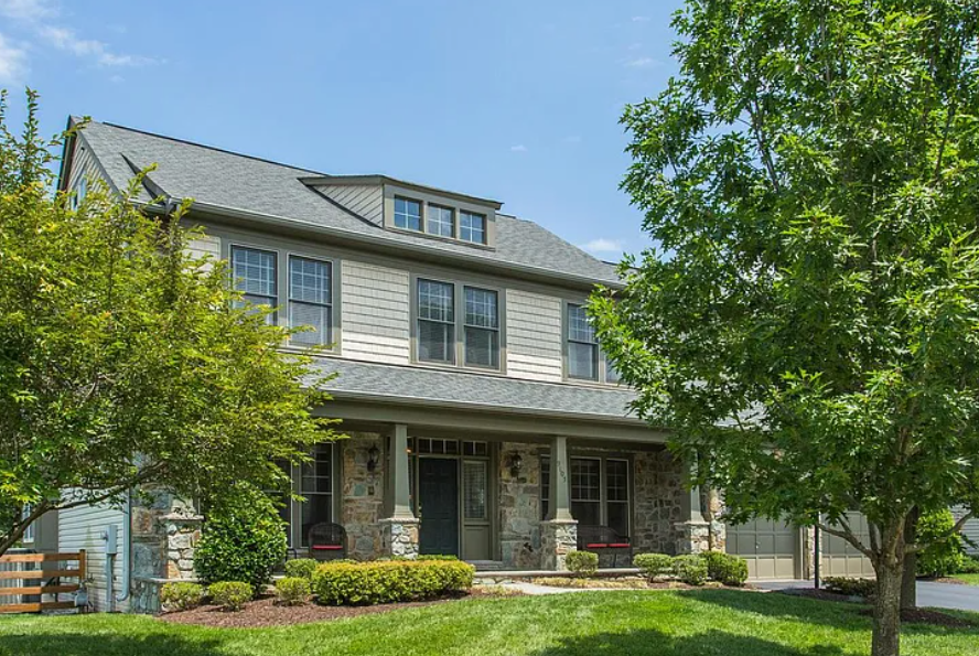 Front exterior of 9105 Acadia Park Dr in Bristow, with porch, lawn and mature trees