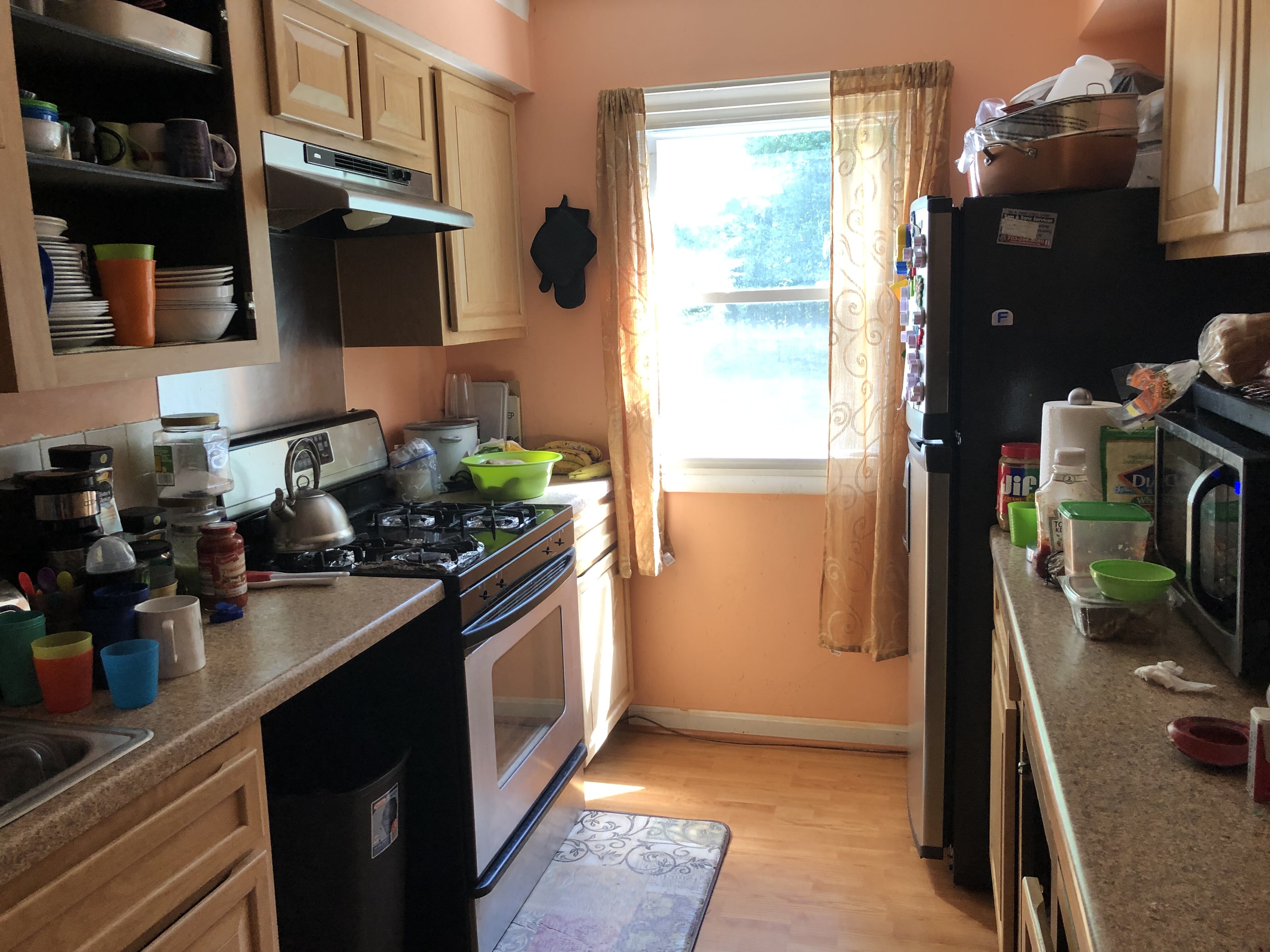 Kitchen at 14648 Bakersfield St with wood cabinets, appliances and household belongings