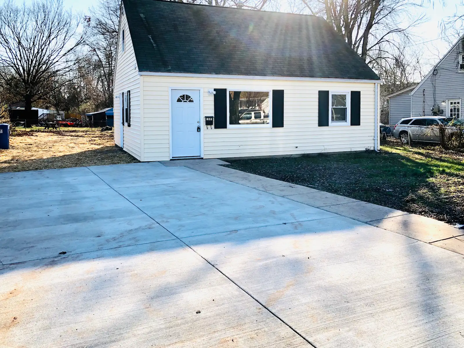 Front exterior of 165 Cabbel Dr in Manassas Park, with white siding, dark shutters and a concrete driveway