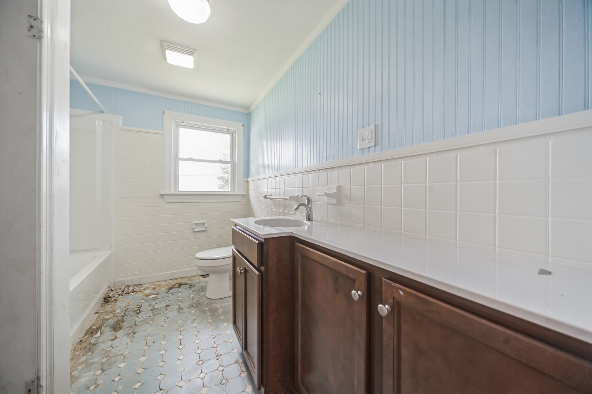 Bathroom at 107 Cedar St, with long vanity, blue upper wall and tiled floor