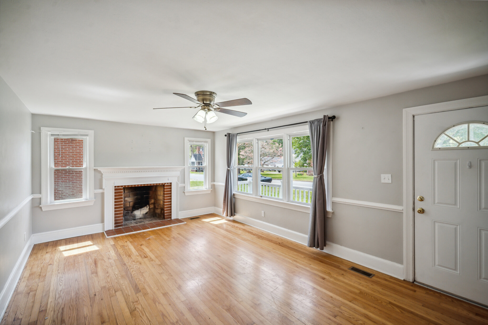 Living room at 107 Cedar St, with wood flooring, fireplace and large windows