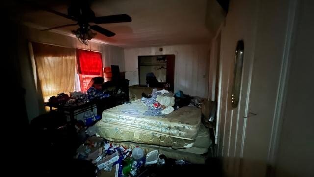 Bedroom at 517 Denton St with a mattress, belongings and debris