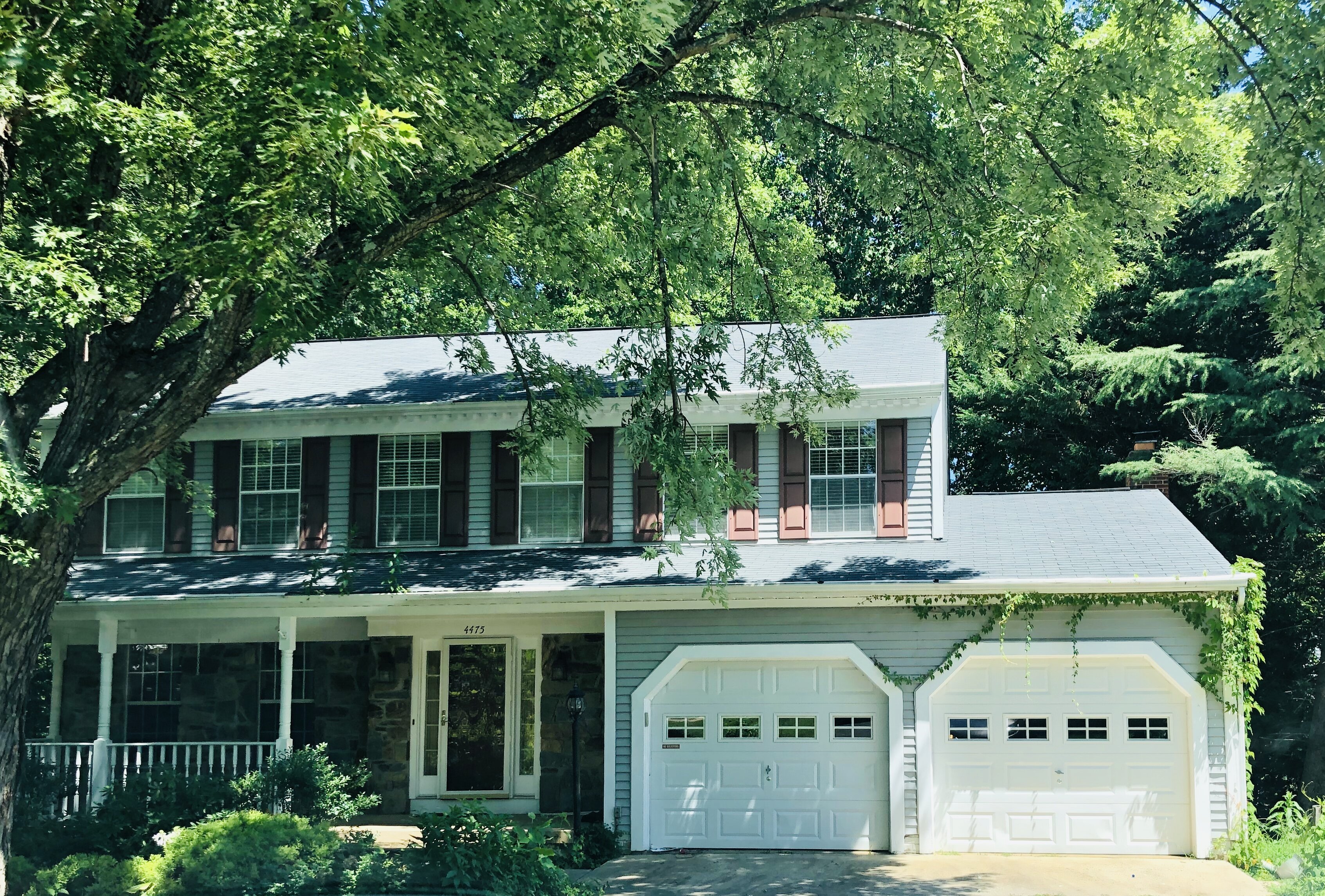 Front of 4475 Edsall Dr in Woodbridge, with covered porch, two garage doors and mature trees