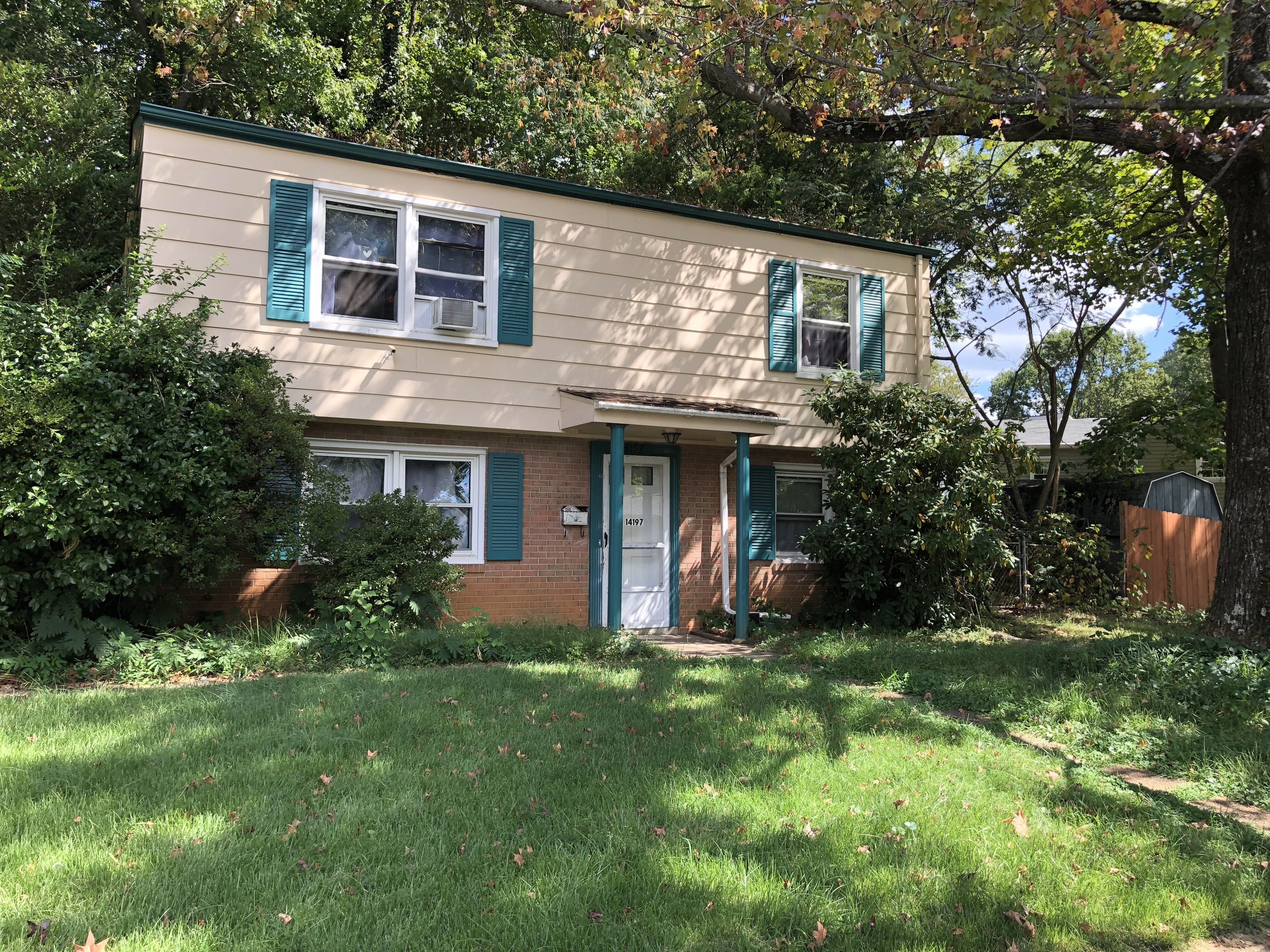 Front of 14197 Fullerton Rd in Woodbridge, with light siding, brick and mature trees