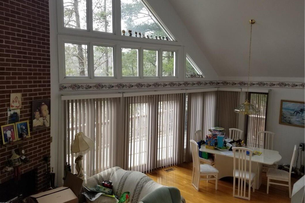 Living area at 77 Linda Dr with furnishings and belongings beneath tall windows