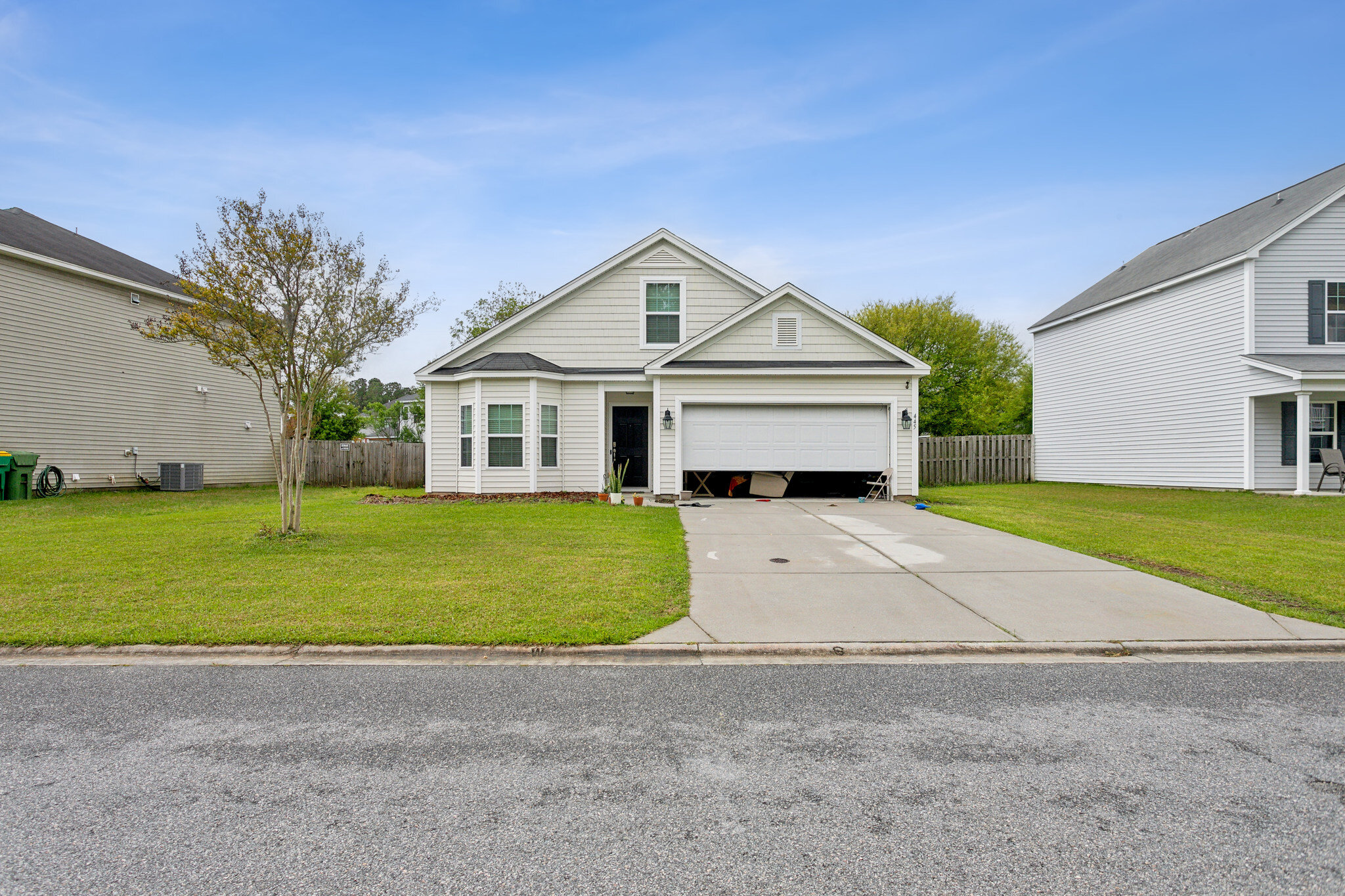 Front of 445 Lions Den Dr in Pooler before the sale, showing the lawn, driveway and garage