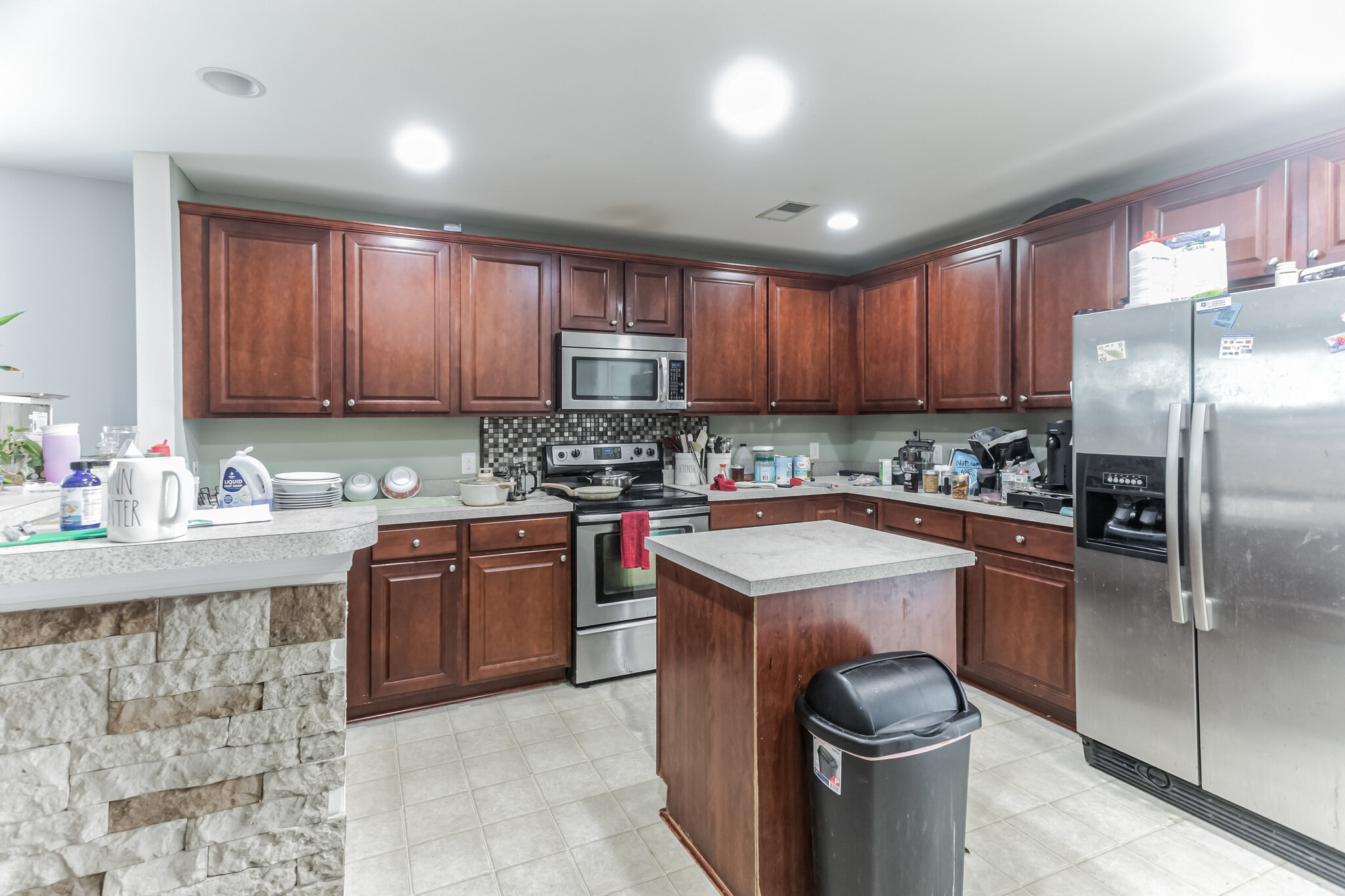 Kitchen at 445 Lions Den Dr before updates, with wood cabinets, an island and household items