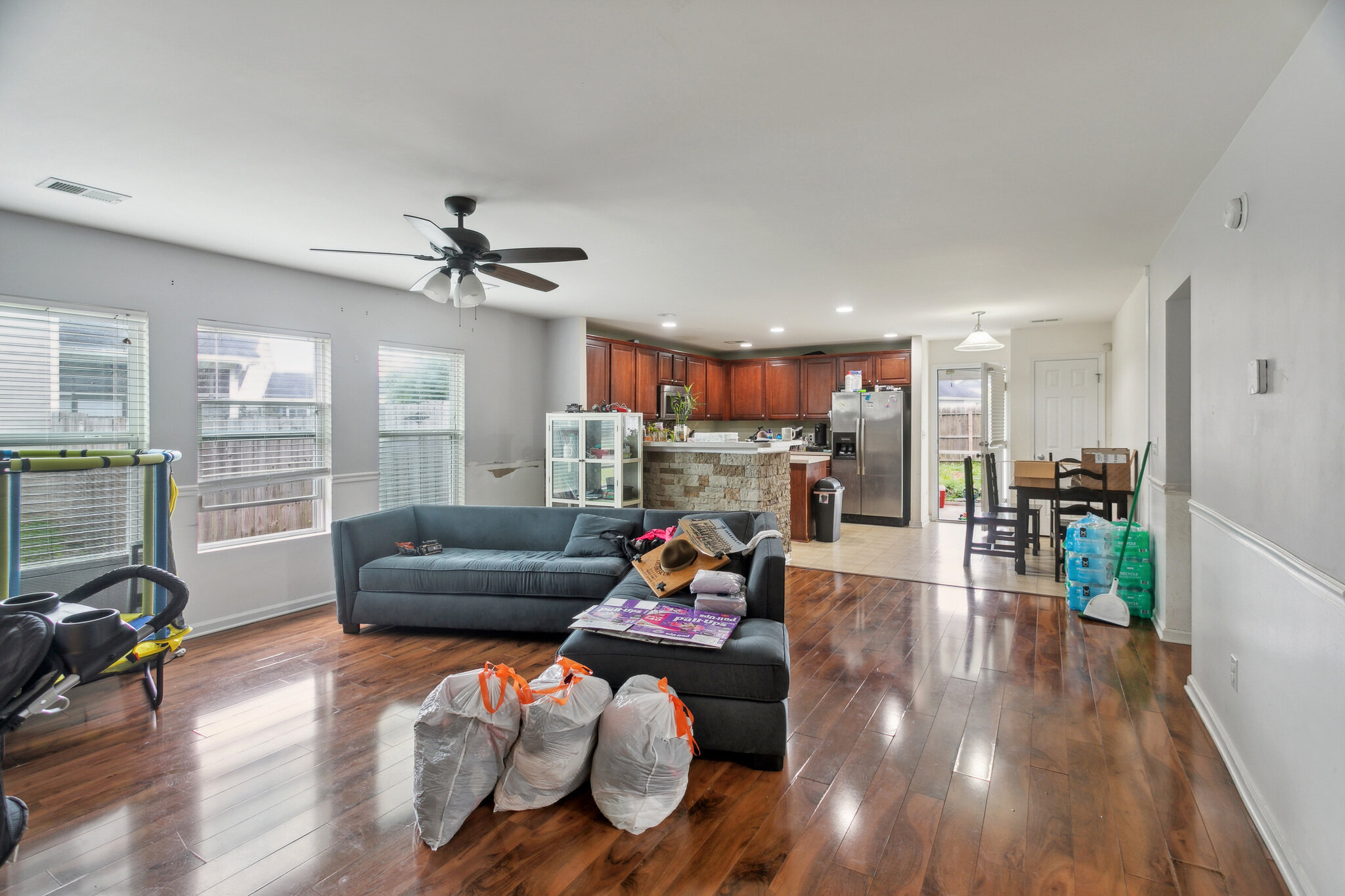Living room at 445 Lions Den Dr before updates, with furniture, belongings and wood flooring