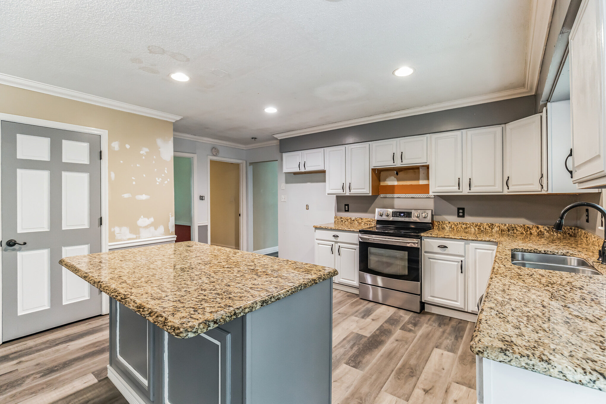 Kitchen at 2002 Pinewood Terrace in later photos, showing an island, light cabinets and granite counters