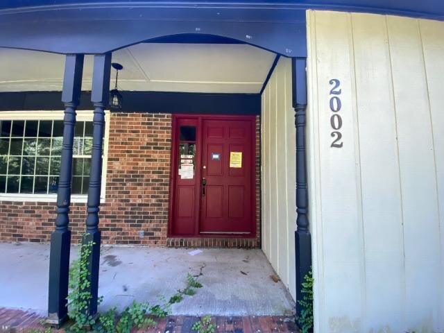 Front entry at 2002 Pinewood Terrace in Fayetteville before updates, with red door and visible house number