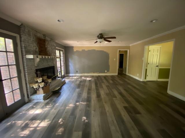 Living room at 2002 Pinewood Terrace before updates, with stone fireplace and unfinished wall areas