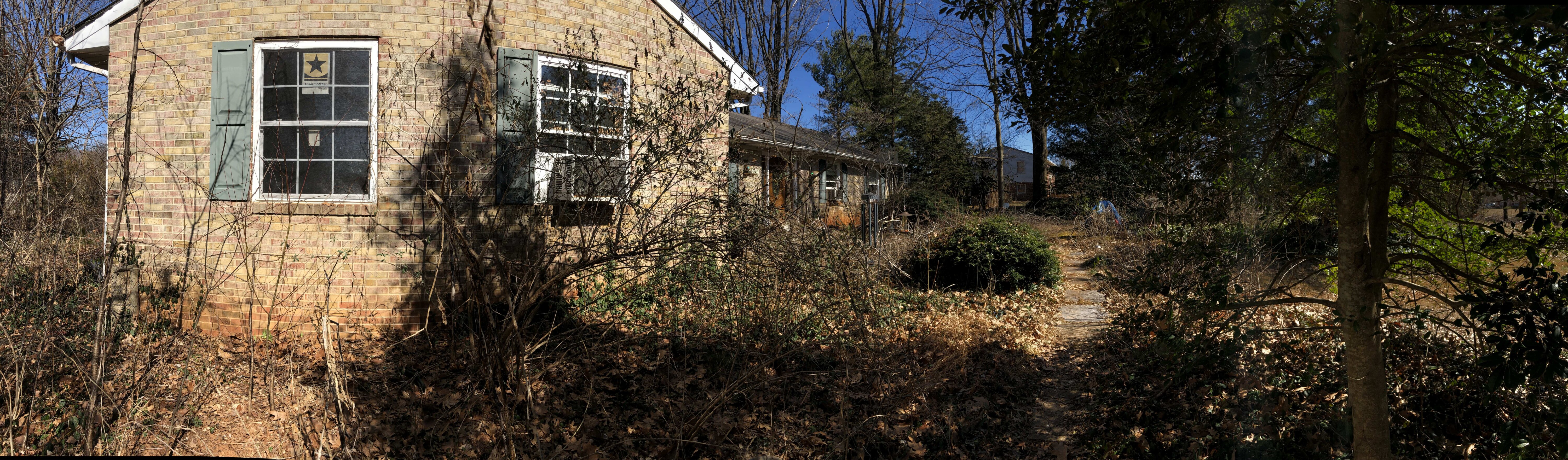 Panoramic view of 16310 Poplar Hill Rd with brick exterior, overgrown vegetation and a shaded path