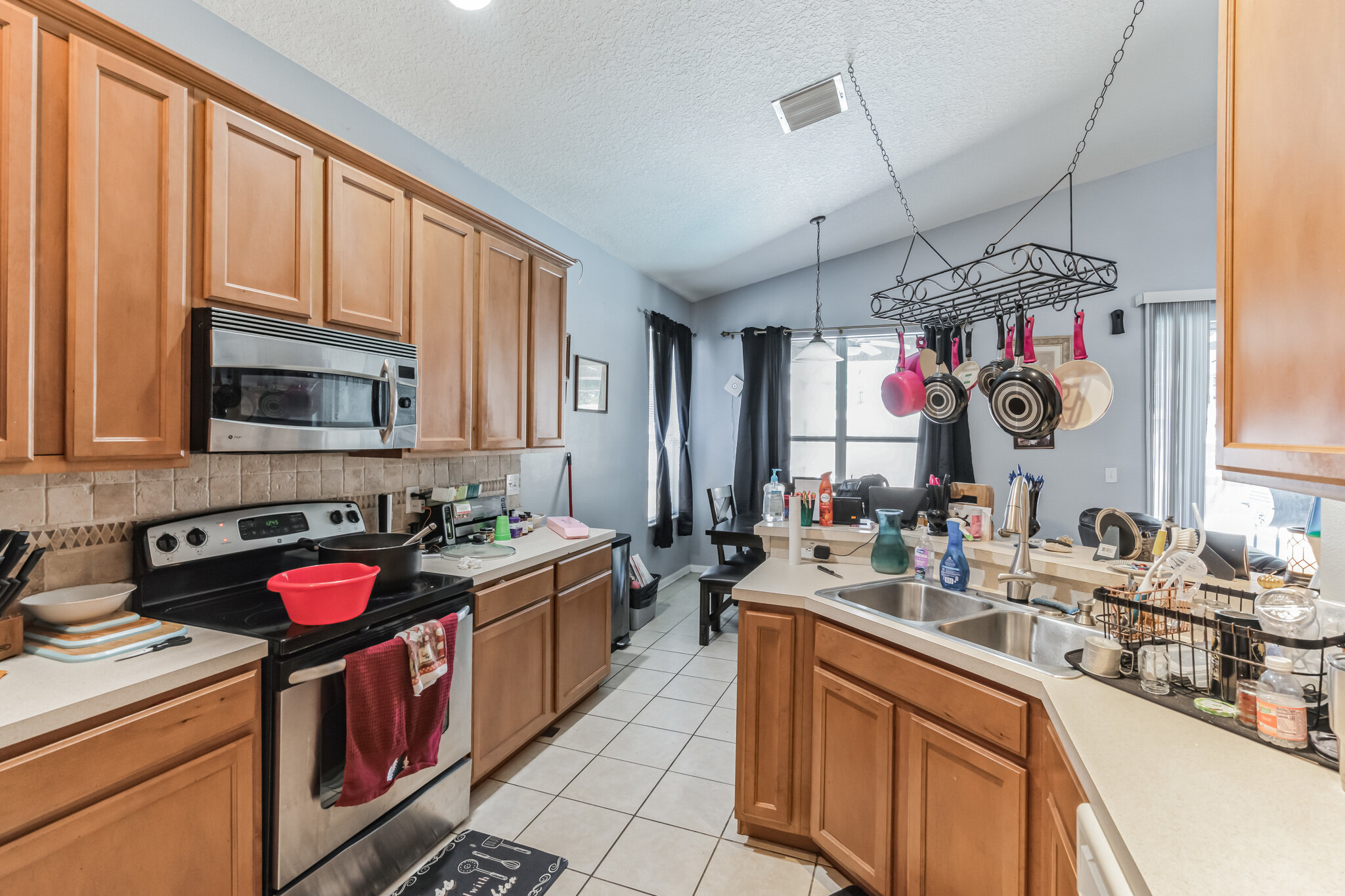 Kitchen with wood cabinets and hanging pot rack at 11028 Silver Dancer Dr in Riverview