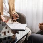 A home buyer and a client shaking hands after selling a house