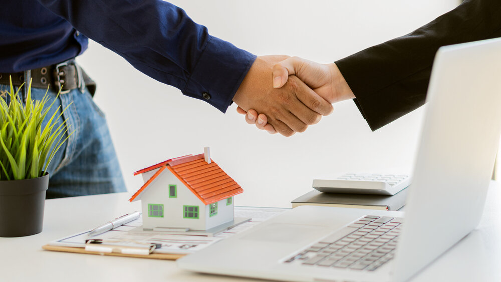 Real estate agent shaking hands with customer after offering a fast cash offer