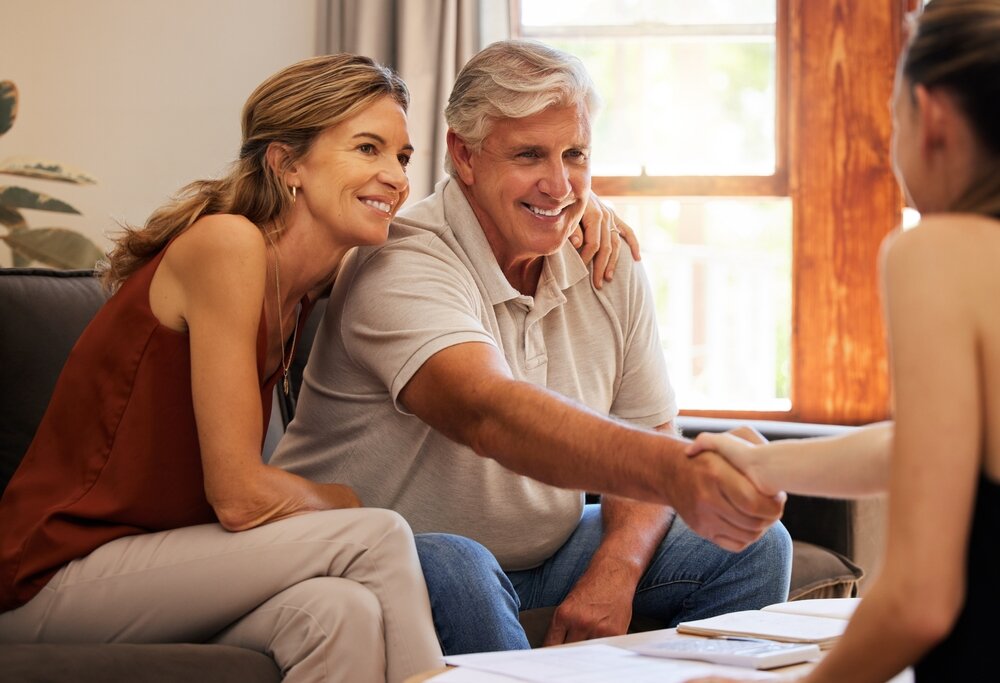 Real estate, family home and senior couple doing handshake with agent to sell house.