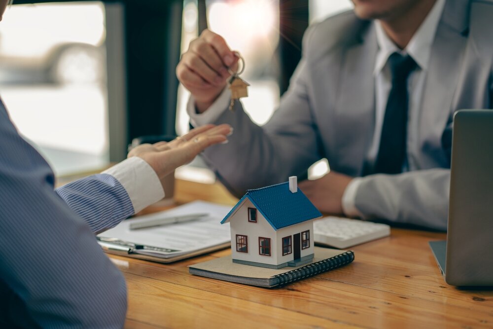 Homeowner giving house keys to a homebuyer after getting a fair cash offer