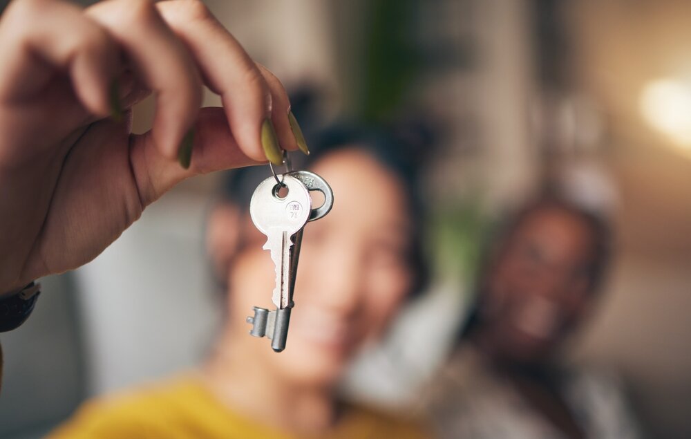 Keys, hand and new home or people moving in together for real estate investment.