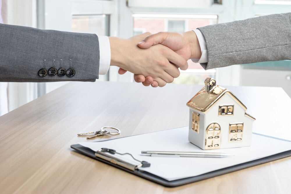 A home buyer and a client shaking hands after selling a house in St. Paul, MN