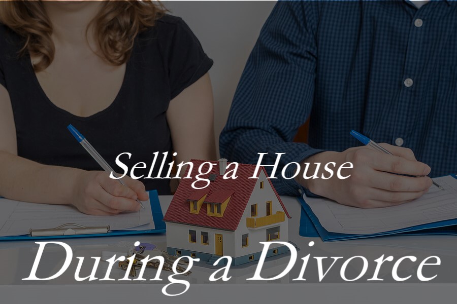 A man and woman signing divorce papers with a model of a house in front of them