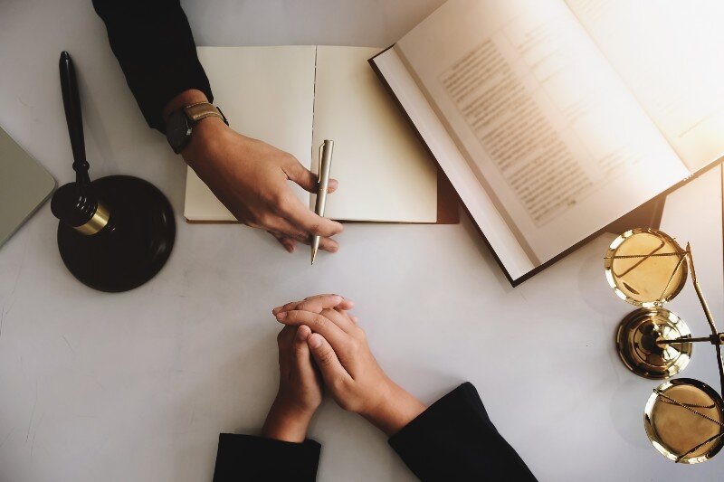 A lawyer assisting a client over some documents.