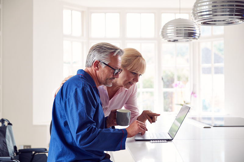 A couple of elderly homeowners reading online about the worst times of the year to sell a house in Wisconsin